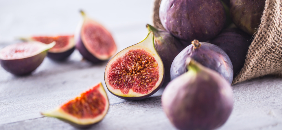 A few figs freely lying on old wooden table.